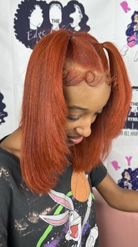 a woman with red hair sitting in front of a t - shirt